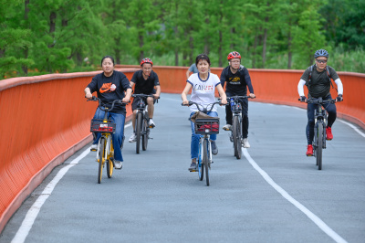 2023年6月4日，市民骑游在成都锦城湖公园绿道上。